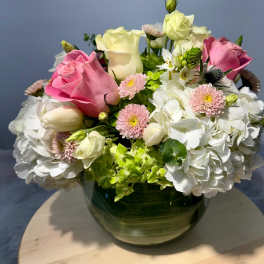Pink and white roses with hydrangeas in a glass vase