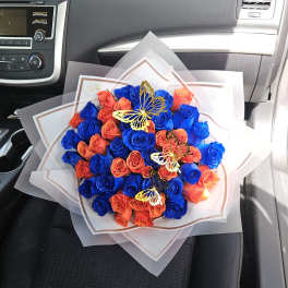 Bouquet of blue and orange roses with butterfly decorations