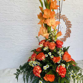 Tall orange floral arrangement with roses and gladiolus