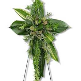 Green floral cross with cascading foliage on a stand