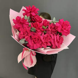 Large bouquet of bright pink flowers wrapped in pale pink paper
