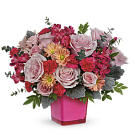 Pink and peach mixed bouquet in a bright pink vase