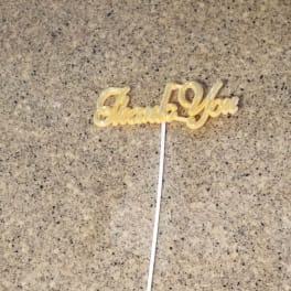 Gold "Thank You" cake topper on a white stick