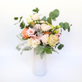 Pastel bouquet of roses and ranunculus in a white vase