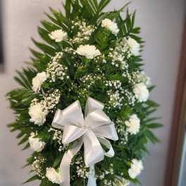 White floral standing spray with a satin bow