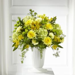Yellow and white floral arrangement in a white vase