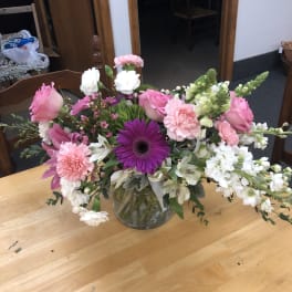 Pink and white mixed flower arrangement in a clear glass vase
