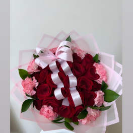 Bouquet of red roses and pink carnations with a pale pink ribbon