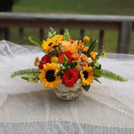 Bright bouquet of sunflowers and red roses in a glass vase