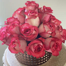 Pink roses arranged in a decorative silver vase