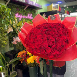 Large bouquet of red roses wrapped in red paper