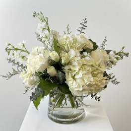 White hydrangea and roses in a clear glass vase