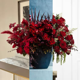 Large red floral arrangement in a dark vase