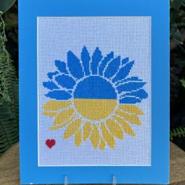 Blue and yellow sunflower design on a framed needlepoint panel