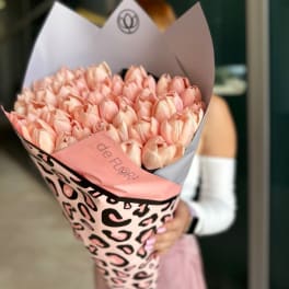 Bouquet of pale pink tulips wrapped in patterned paper