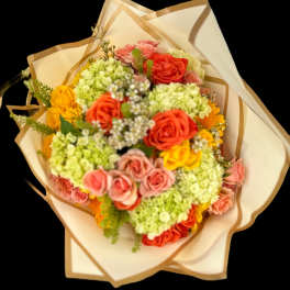 Bouquet of roses and hydrangeas wrapped in cream paper