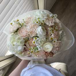 Bouquet of pale pink and white flowers wrapped in white paper