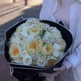 Bouquet of cream roses and small white daisies wrapped in black paper