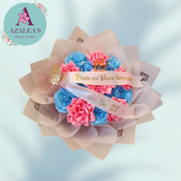 Bouquet of blue and pink roses wrapped in pale pink paper