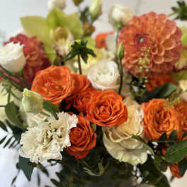 Orange and white roses with a peach dahlia in a vase