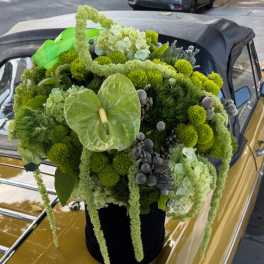 Green floral arrangement with hydrangeas and anthurium on a car