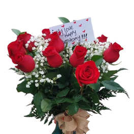 Bouquet of red roses in a vase with a birthday card