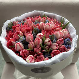 Bouquet of pink and red tulips wrapped in white paper