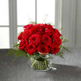 Red roses arranged in a clear glass vase