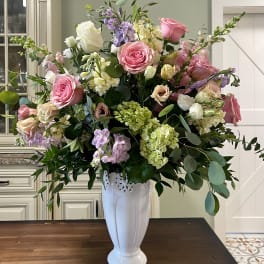 Large pink and white floral arrangement in a white vase