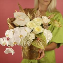 White orchid and rose arrangement in a gold container