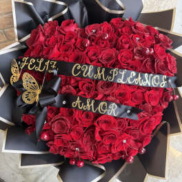 Heart-shaped bouquet of red roses with black ribbon and gold accents