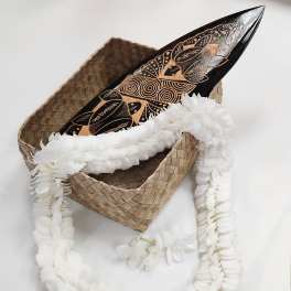 White flower garland draped over a woven basket with a carved wooden object