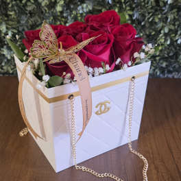 Red roses in a white gift box with a gold butterfly ribbon