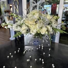 White rose arrangement in a silver gift bag with a sheer bow