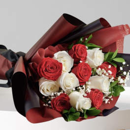 Bouquet of red and white roses wrapped in burgundy and black paper