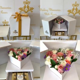 White gift box with pink and white roses and chocolates inside