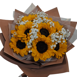 Hand-tied bouquet of bright yellow sunflowers with small white filler blooms wrapped in brown paper