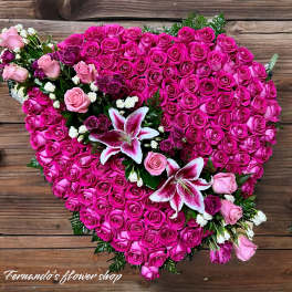 Heart-shaped arrangement of hot pink roses accented with pink roses and pink-white lilies.