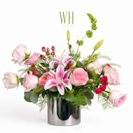 Pink roses and lilies arranged in a silver vase