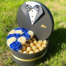 Black tuxedo-shaped gift box with blue and white roses and chocolates