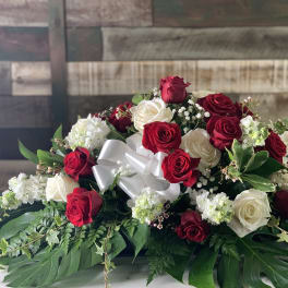 Red and white rose arrangement with a white ribbon bow