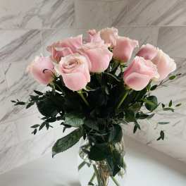 Pink roses arranged in a clear glass vase