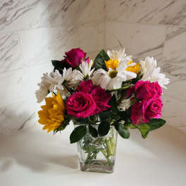 Pink roses and white daisies in a clear glass vase