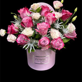 Pink and white roses arranged in a lavender hat box