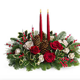 Holiday centerpiece with red candles, roses, pinecones, and evergreen branches