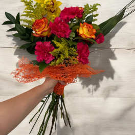 Handheld bouquet of orange-yellow roses and hot pink carnations