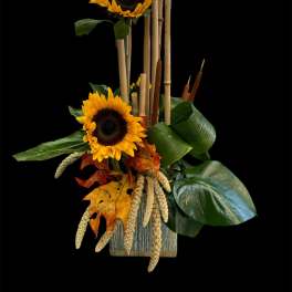 Sunflower arrangement with autumn leaves and bamboo sticks