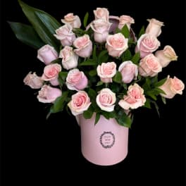 Pink roses arranged in a pale pink hatbox