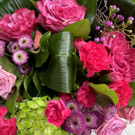 Pink and magenta rose bouquet with green hydrangeas and purple button flowers