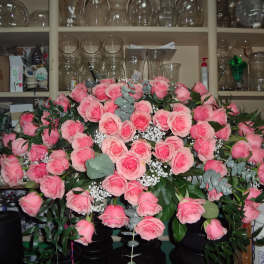 Large bouquet of pink roses with baby's breath in a vase